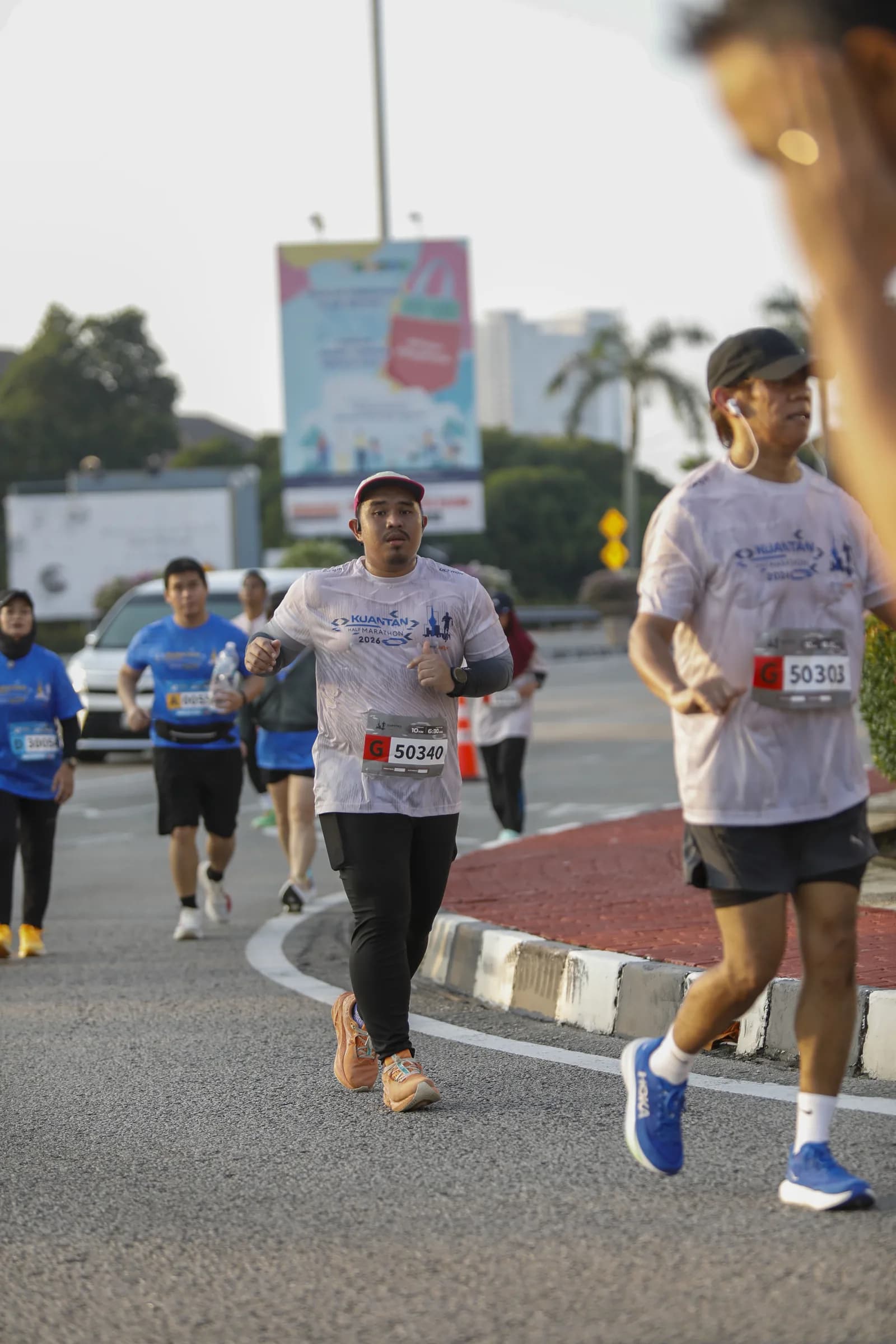 Razeen running in a road race with a race bib